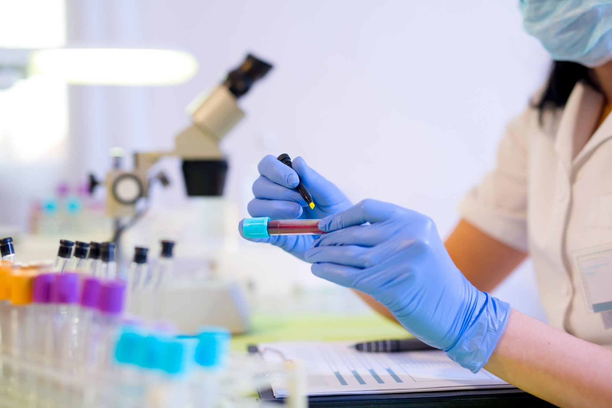 Woman working in a laboratory, writing with a felt pen.