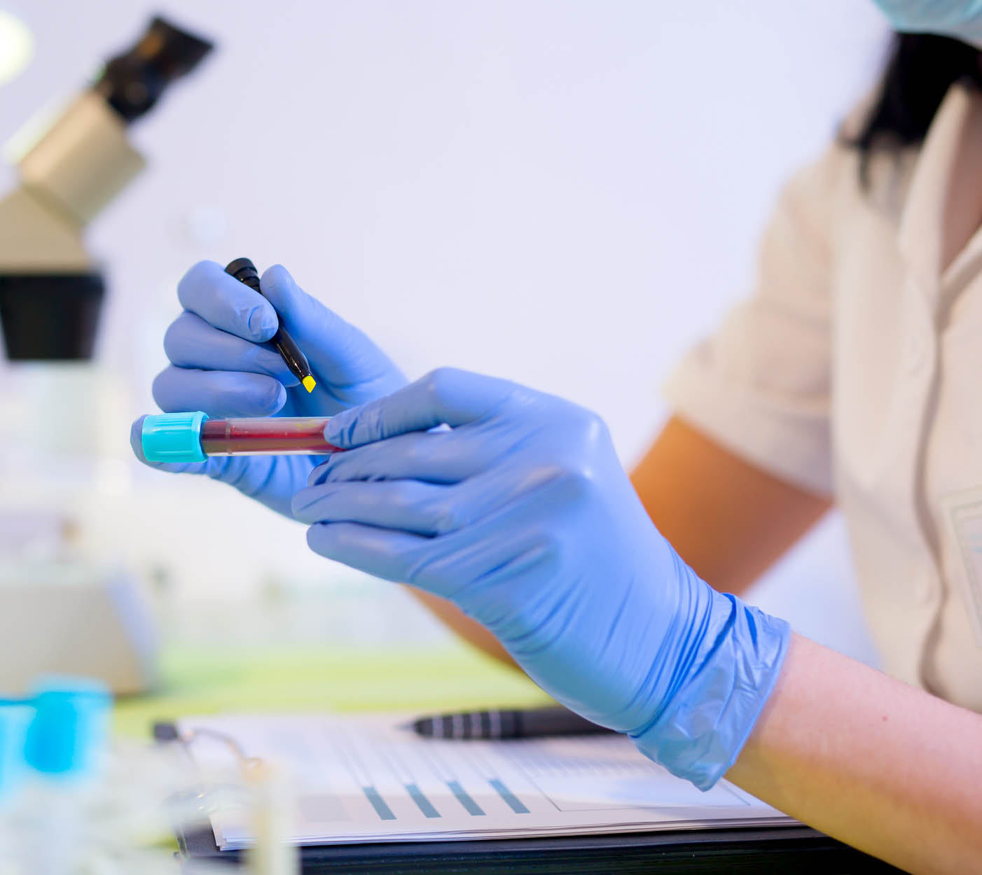 Woman working in a laboratory, writing with a felt pen.